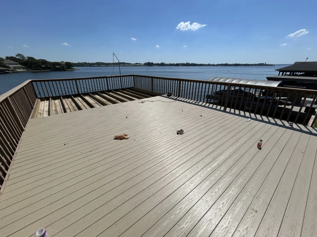 55060 A beige composite deck in the process of being built, overlooking a lake with houses along the far shore.